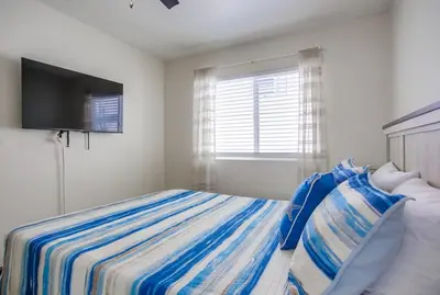 a bedroom with a bed with a television on the wall at Manhattan Shores 5 in San Diego