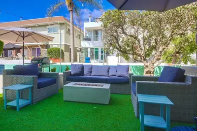 a patio with couches and tables and an umbrella at Manhattan Shores 5 in San Diego