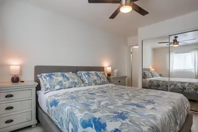 a bedroom with a bed and a dresser and a mirror at Manhattan Shores 5 in San Diego