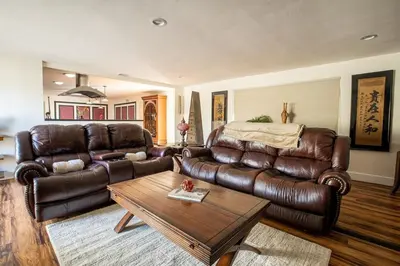 a living room with a leather couch and a table at Poker and Golf Club, Stream movies & Sports in San Diego
