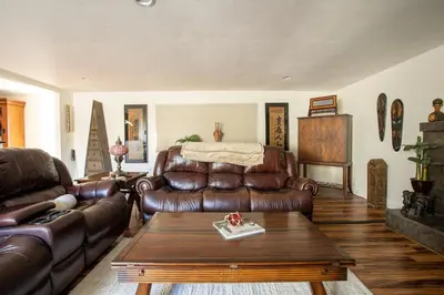 a living room with a leather couch and a table at Poker and Golf Club, Stream movies & Sports in San Diego