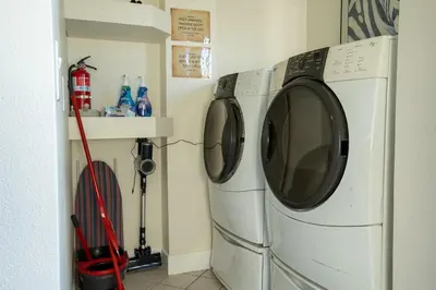 two washing machines sitting next to each other in a laundry room at Poker and Golf Club, Stream movies & Sports in San Diego