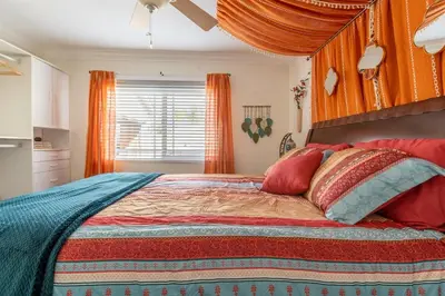 a bedroom with a large bed with orange curtains at Poker and Golf Club, Stream movies & Sports in San Diego