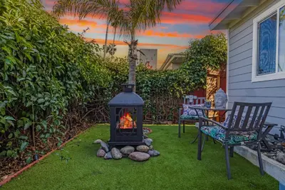 a fireplace in a yard with a chair and a table at Cozy Coastal Escape Beach & Brews in San Diego