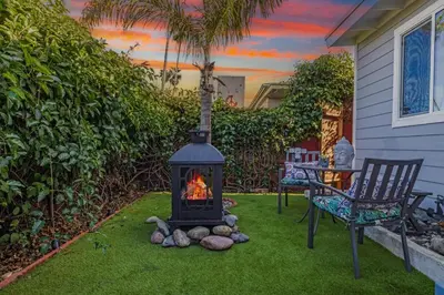 a fireplace in a yard with a chair and a table at Cozy Coastal Escape Beach & Brews in San Diego