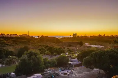 a sunset over a park with a city in the background at Home to enjoy the beach with ocean view in Oceanside