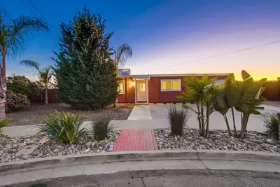 a home with palm trees and a red house at Home to enjoy the beach with ocean view in Oceanside