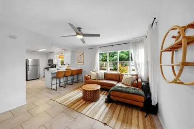 a living room with a couch and a kitchen at Carlsbad Beach Bungalow in Carlsbad