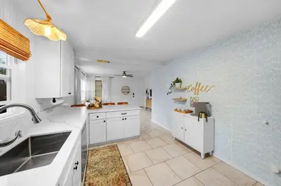 a kitchen with white cabinets and a blue wall at Carlsbad Beach Bungalow in Carlsbad