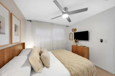 a bedroom with a bed with a ceiling fan at Carlsbad Beach Bungalow in Carlsbad