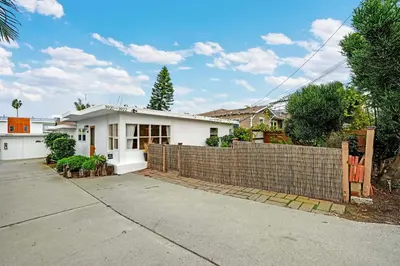 a white house with a fence in front of it at Carlsbad Beach Bungalow in Carlsbad