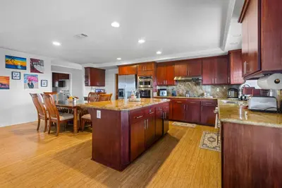 a large kitchen with wooden cabinets and a dining table at Temecula Valley Private Estate Panoramic Mountain & Pool Views in Murrieta