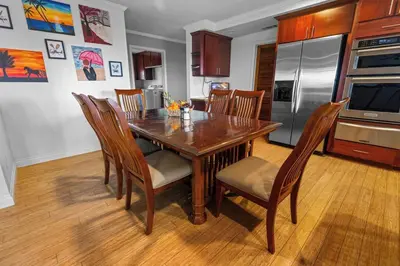 a kitchen with a wooden table with chairs and a refrigerator at Temecula Valley Private Estate Panoramic Mountain & Pool Views in Murrieta