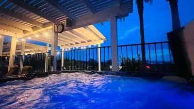 a hot tub on a balcony at night at Temecula Valley Private Estate Panoramic Mountain & Pool Views in Murrieta