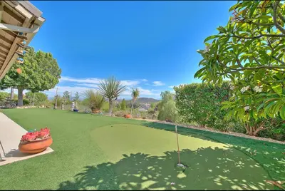 a putting green with a golf ball on it at Temecula Valley Private Estate Panoramic Mountain & Pool Views in Murrieta