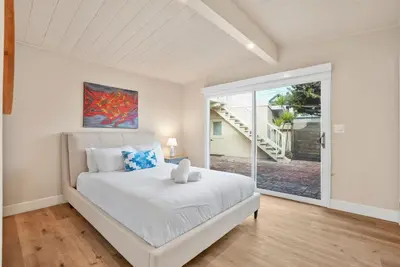 a bedroom with a white bed and a large window at Oceanfront Paradise on Neptune in Encinitas