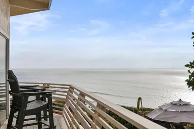 a balcony with a table and chairs and the ocean at Oceanfront Paradise on Neptune in Encinitas