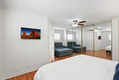 a white bedroom with a bed and a couch at Beachfront Getaway with Ocean Views and Private Patio in Newport Beach