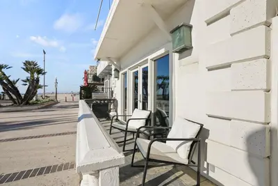 a row of chairs on a sidewalk next to a building at Beachfront Getaway with Ocean Views and Private Patio in Newport Beach