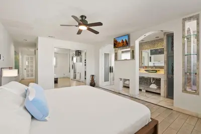 a white bedroom with a bed and a ceiling fan at Beachfront Retreat with Ocean Views Private Rooftop Deck Walk to Pier and Town in Newport Beach