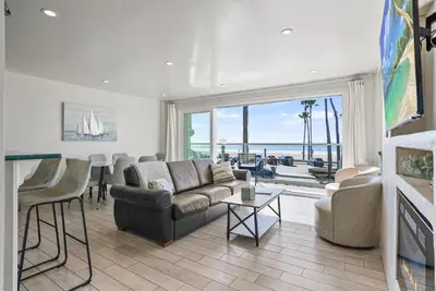 a living room with a couch and a table at Beachfront Retreat with Ocean Views Private Rooftop Deck Walk to Pier and Town in Newport Beach