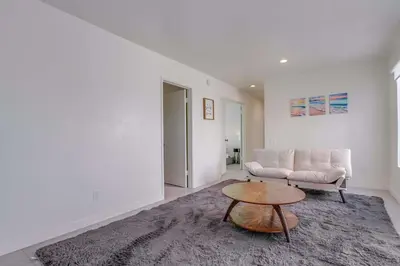 a living room with a couch and a table at 2nd floor A-C steps to beach downtown La Jolla in San Diego