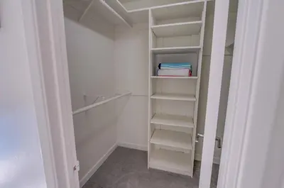 a white walk in closet with white shelves at 2nd floor A-C steps to beach downtown La Jolla in San Diego
