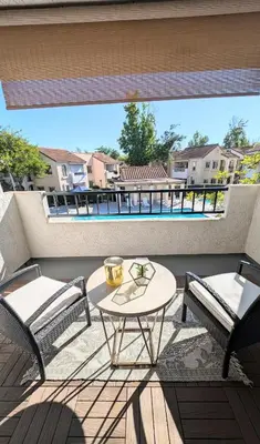 a patio with a table and chairs on a balcony at Poolside 2BR Condo with Balcony & Workspace in San Diego