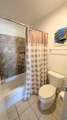 a bathroom with a toilet and a shower at Poolside 2BR Condo with Balcony & Workspace in San Diego