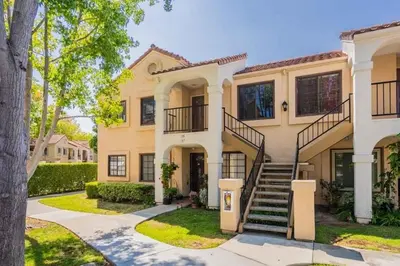 a large house with a staircase in a yard at Poolside 2BR Condo with Balcony & Workspace in San Diego