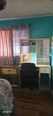 a bedroom with a desk and a chair next to a window at Choice of comfort in Hemet