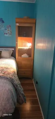 a bedroom with a bed and a cabinet with a window at Choice of comfort in Hemet
