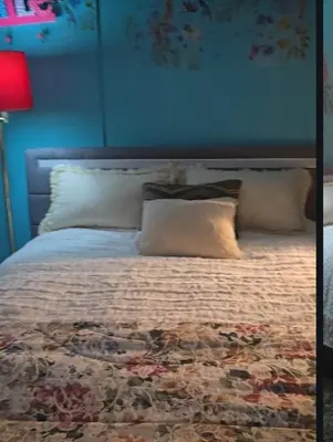 a bedroom with a bed with pillows and a blue wall at Choice of comfort in Hemet