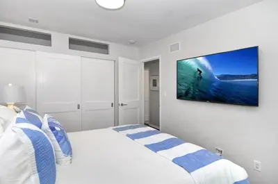 a bedroom with a bed with a tv on the wall at Near Beach, Harbor & Ferry Bikes Patio BBQ in Newport Beach