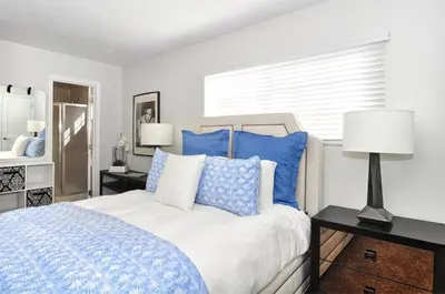 a bedroom with a bed with blue and white pillows at Near Beach, Harbor & Ferry Bikes Patio BBQ in Newport Beach