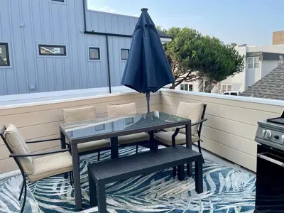 a table and chairs and an umbrella on a balcony at Near Beach, Harbor & Ferry Bikes Patio BBQ in Newport Beach