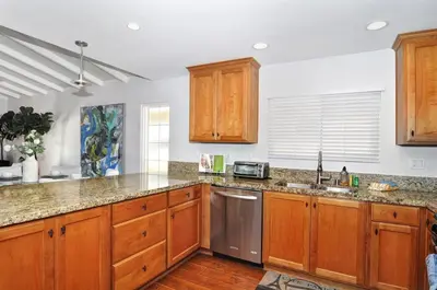 a kitchen with wooden cabinets and stainless steel appliances at Near Beach, Harbor & Ferry Bikes Patio BBQ in Newport Beach