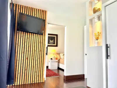 a living room with a flat screen tv on a wall at Private Bedroom & Bathroom Grove, Pool & City View in Oceanside