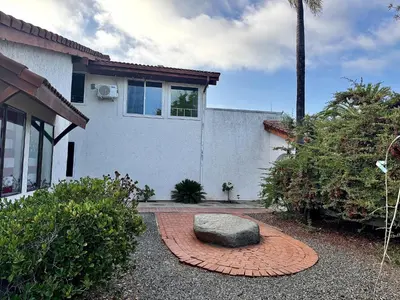 a house with a rock in the middle of a yard at Private Bedroom & Bathroom Grove, Pool & City View in Oceanside
