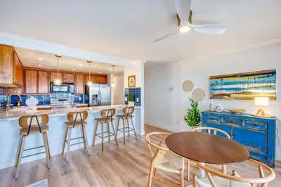 a kitchen with a table and bar with stools at Ocean Harbor View Dana Point in Dana Point