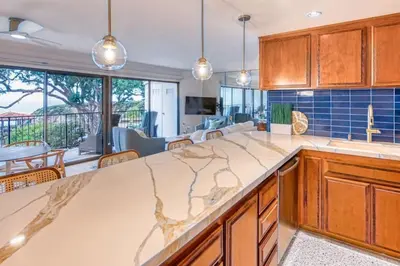 a kitchen with wooden cabinets and a large counter top at Ocean Harbor View Dana Point in Dana Point