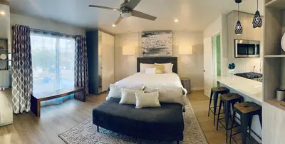 a bedroom with a bed and a table and a kitchen at Stunning Ocean Beach Gem - has everything! in San Diego