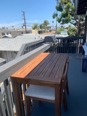 a wooden table and a chair on a deck at Stunning Ocean Beach Gem - has everything! in San Diego