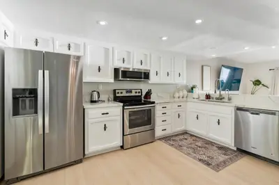 a kitchen with white cabinets and stainless steel appliances at Beachfront Home In Carlsbad - Remodeled in Carlsbad