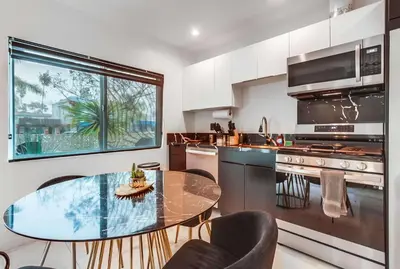 a kitchen with a glass table and a table and chairs at 3 blocks to ocean luxury patio nightlife in San Diego
