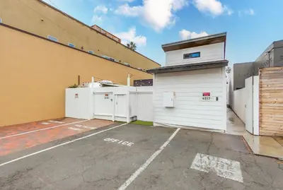 a parking lot with a white garage next to a building at 3 blocks to ocean luxury patio nightlife in San Diego