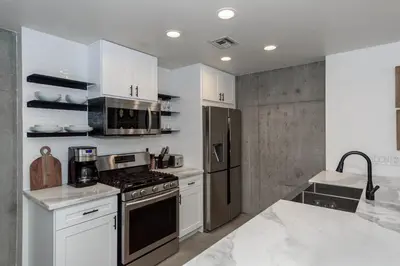 a kitchen with white cabinets and a stove top oven at King Size Luxury Loft Petco-Park-Downtown SD in San Diego