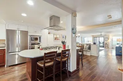 a kitchen with a large island with a counter top at SurfSong Dream - Beachfront in Solana Beach