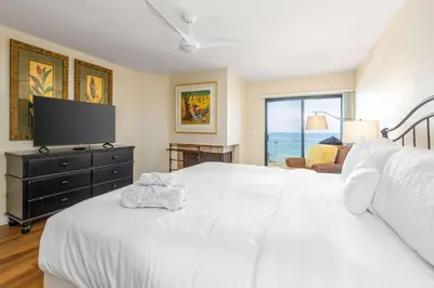 a bedroom with a large white bed and a television at SurfSong Dream - Beachfront in Solana Beach