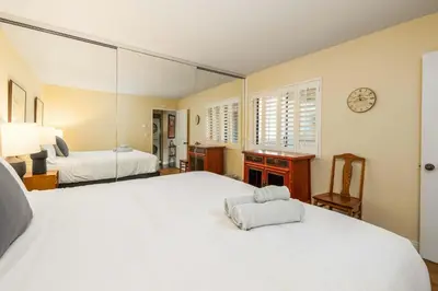 a large bedroom with two beds and a mirror at SurfSong Dream - Beachfront in Solana Beach